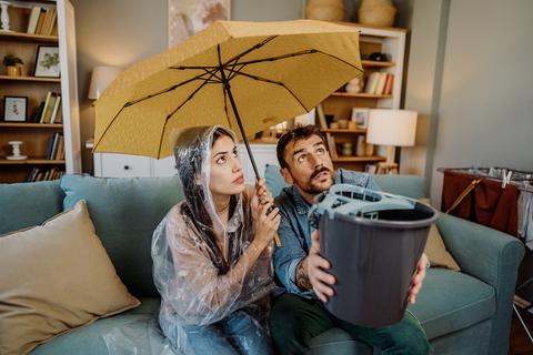 couple catches water leaking through roof into a bucket