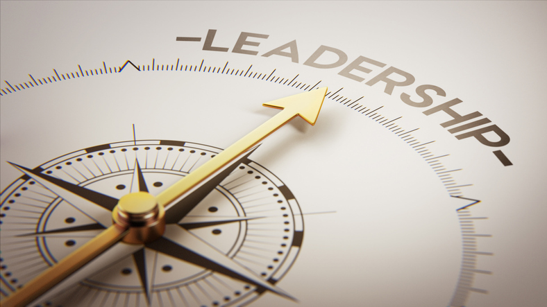 a golden compass pointing toward the word leadership