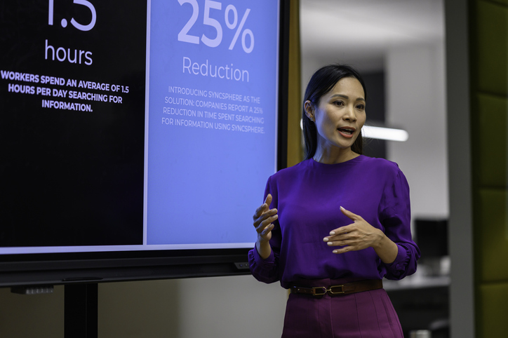 Businesswoman giving presentation in front of digital screen